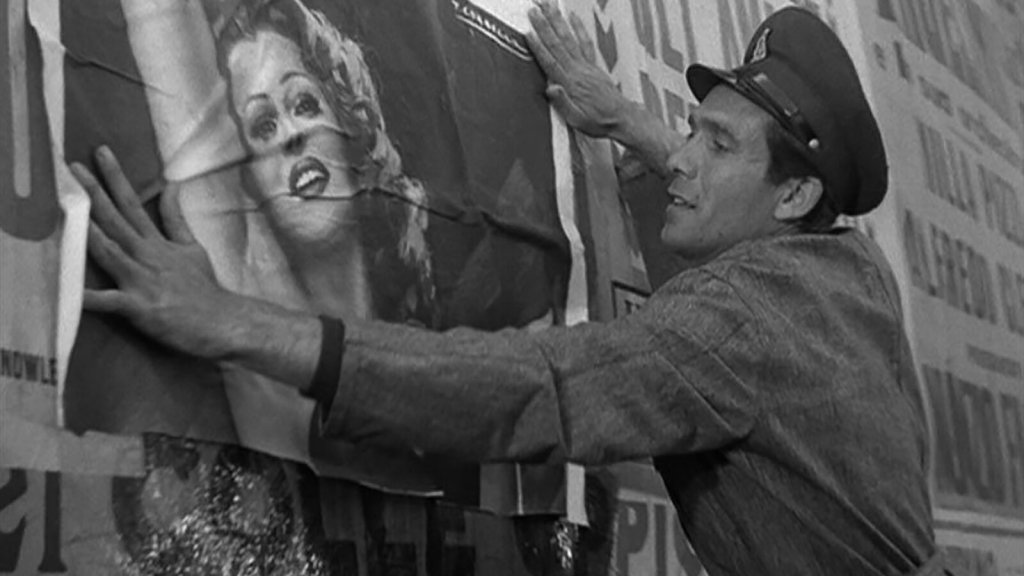 Alberto (Lamberto Maggiorani) hanging a poster of Rita Hayworth in Bicycle Thieves (1948).