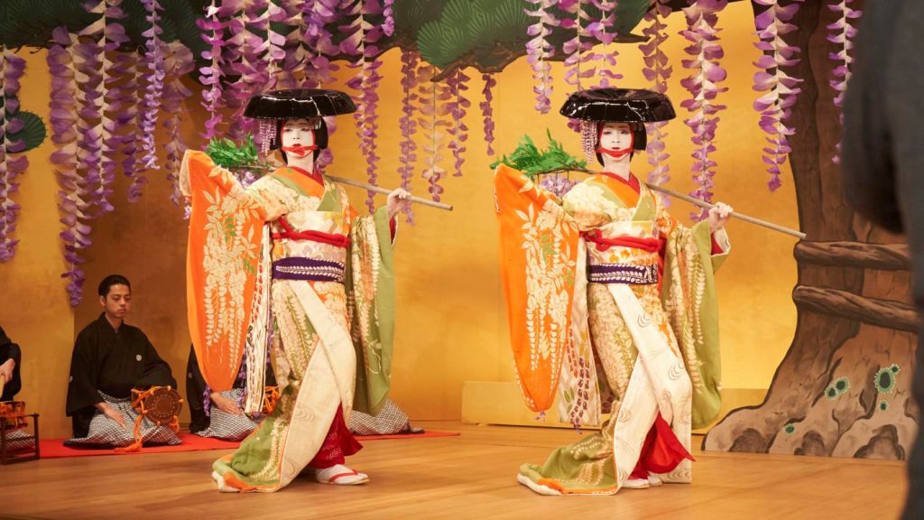 Two onnagata in elaborate costumes perform in full kabuki makeup in a scene from Kokuho.