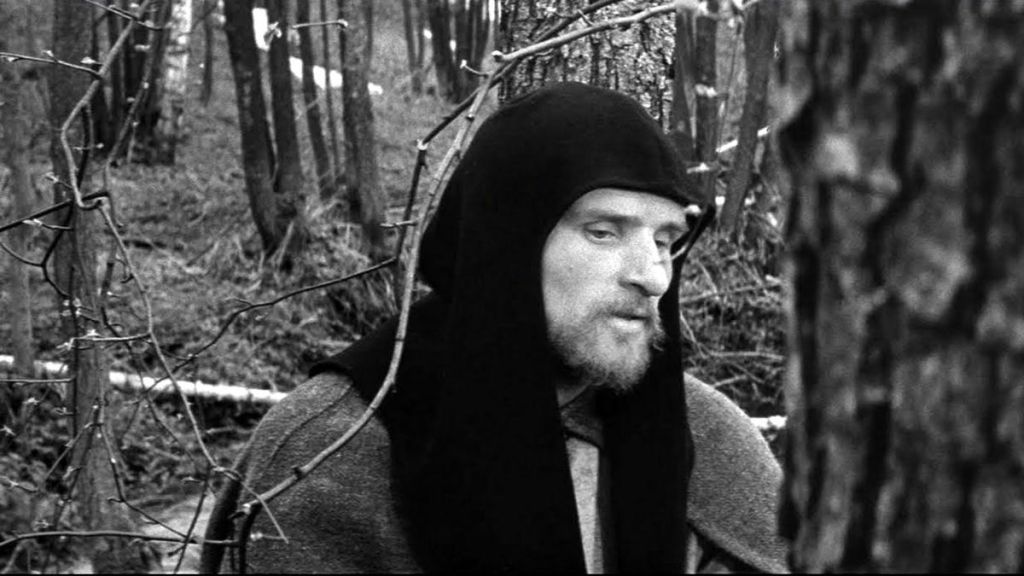 Anatoliy Solonitsyn in a black head covering in the woods in the title role of Andrei Rublev (1966)