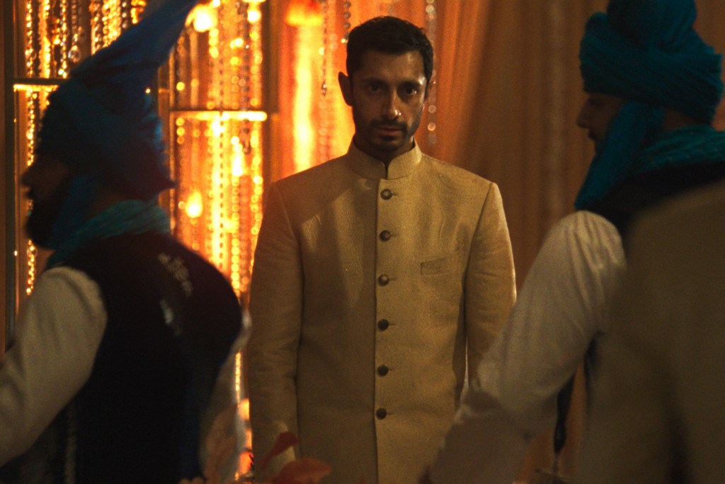 Riz Ahmed in a white jacket in a scene from Hamlet (2026)